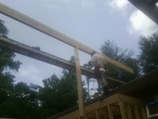 Carpenter setting a ridge beam over a new addition frame — Ice Dam Removal by Roofing Brothers in Long Pine