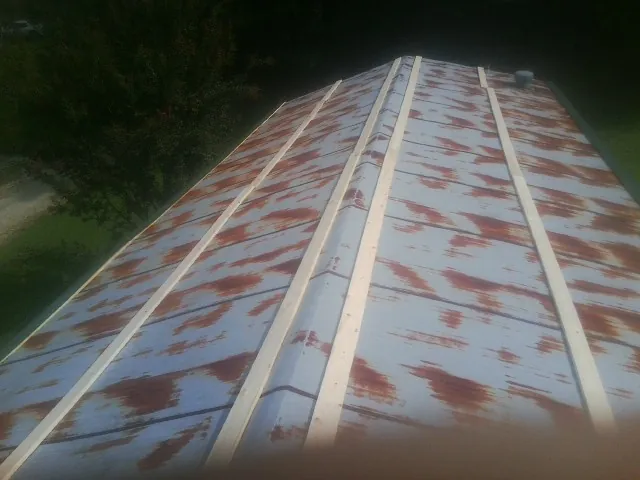 Rusted metal roof panels with new wood purlins before replacement — Storm Damage Roof Repair in Long Pine by Roofing Brothers