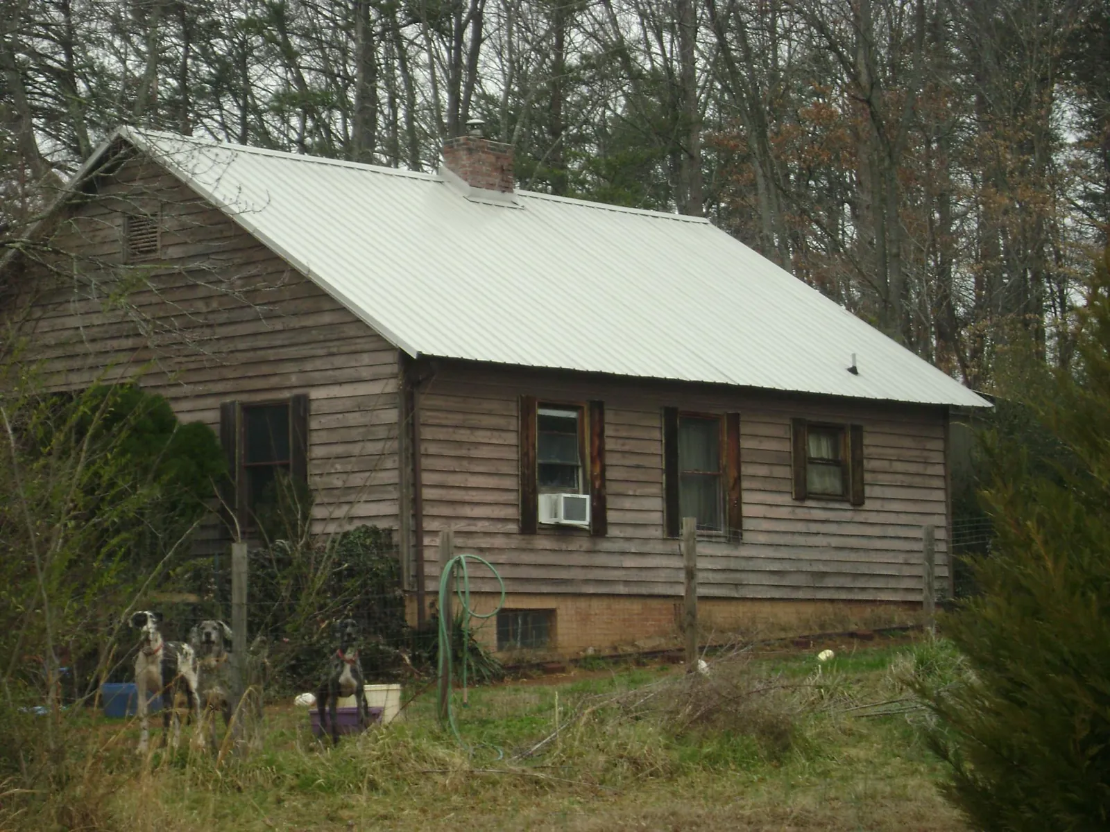 White metal roof on an old wood sided farmhouse, from a Metal Roof Installation job in Long Pine